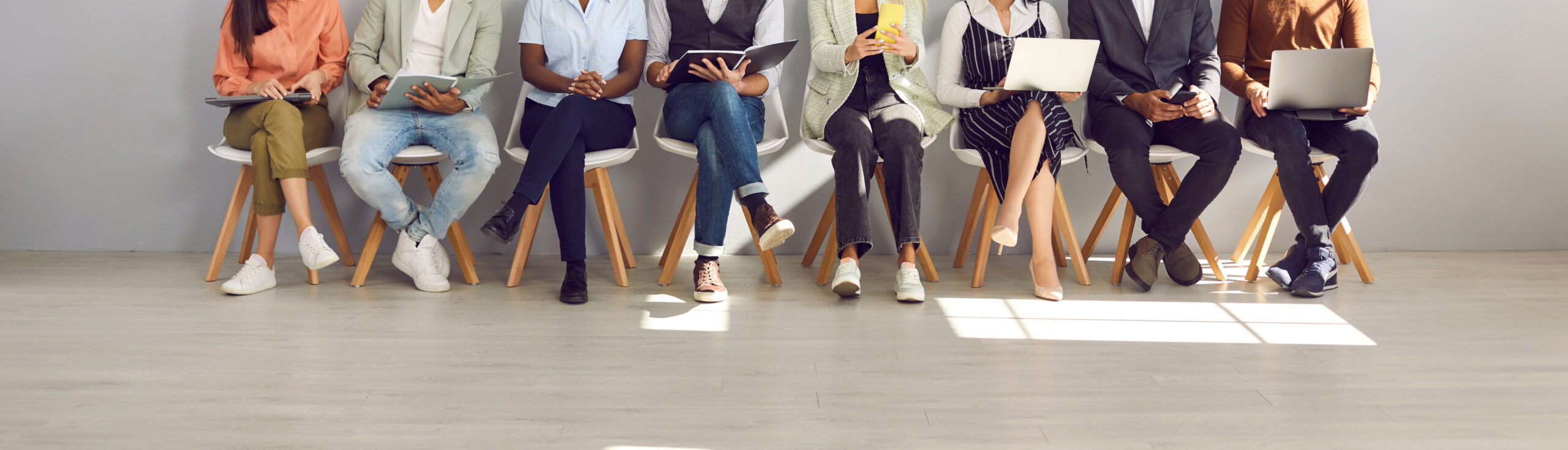 Diverses personnes assises sur des chaises comme si elles attendaient un recrutement